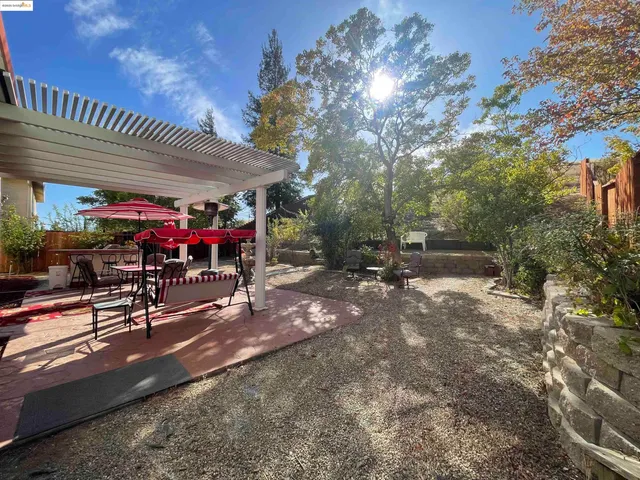 a view of a patio with table and chairs under an umbrella