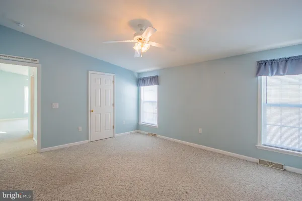a furnished livingroom with a ceiling fan and a window