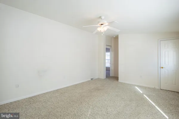 an empty room with an entryway and fan