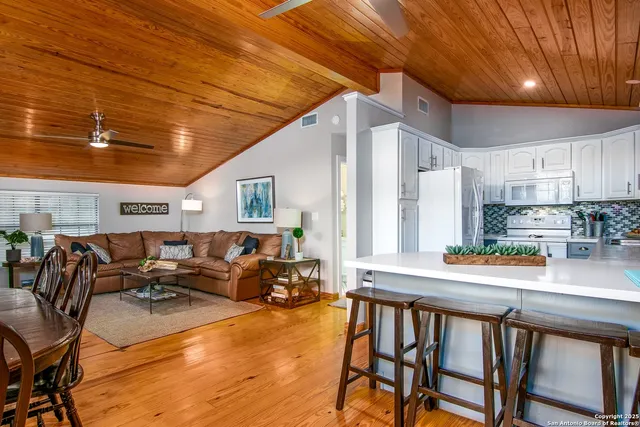 a living room with furniture and a dining table with kitchen view