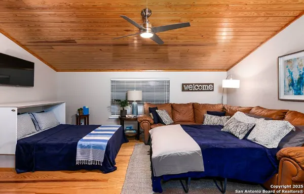 a bedroom with furniture and a flat screen tv