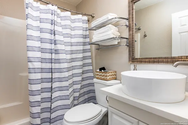 a bathroom with a sink a toilet and a mirror