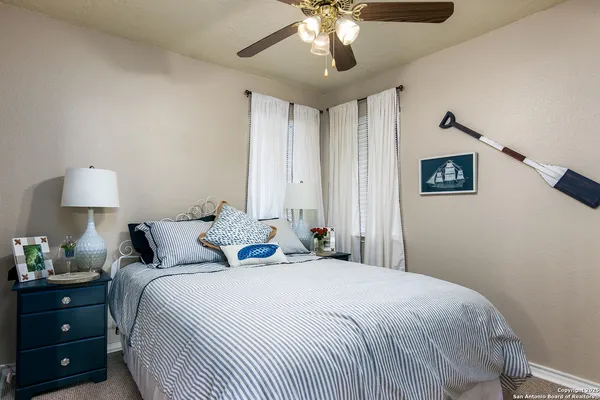 a bedroom with a bed and a lamp on dresser