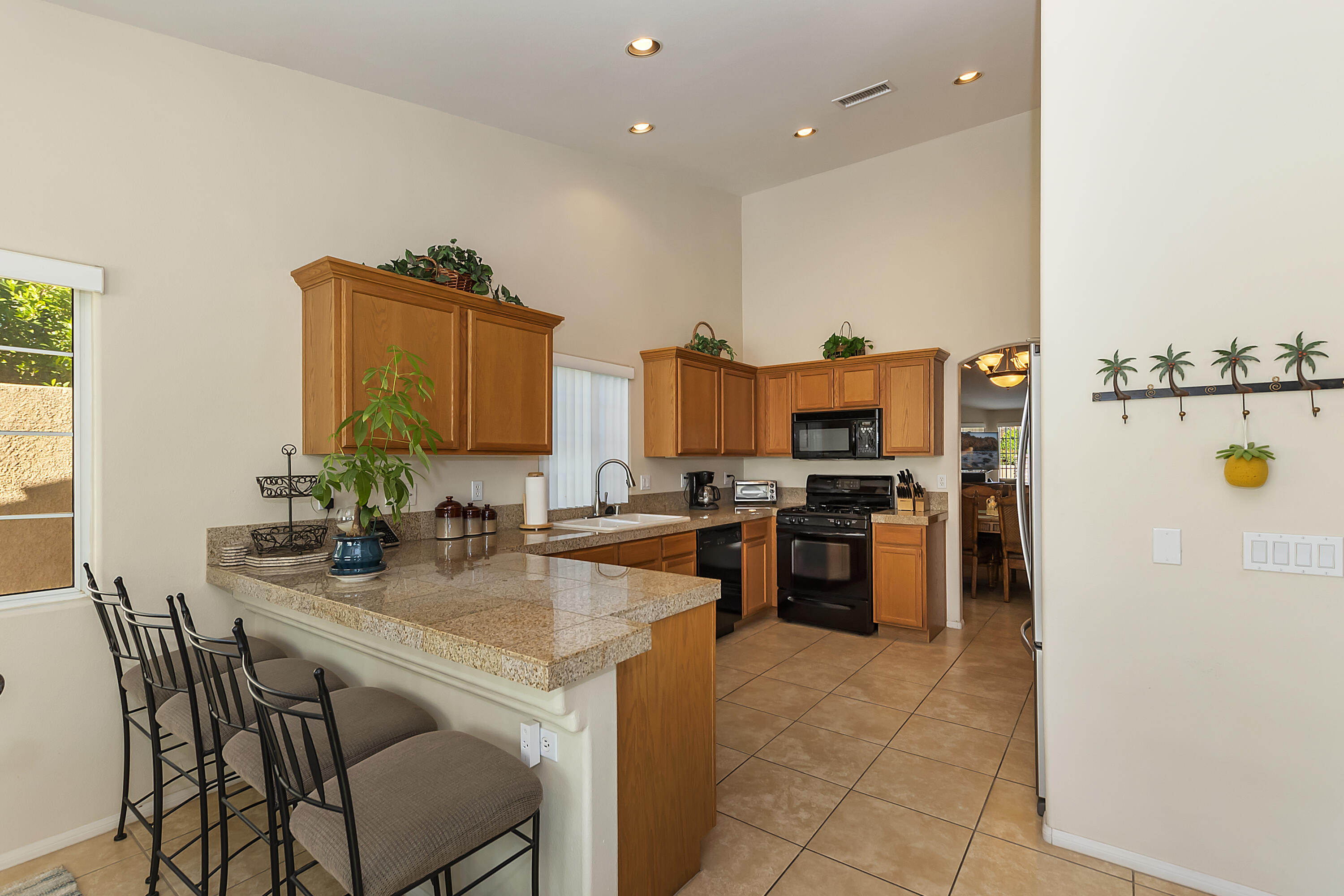 68945 Minerva Road Cathedral City, CA 92234 - Photo 16 of 42 a kitchen with stainless steel appliances granite countertop a stove and a refrigerator