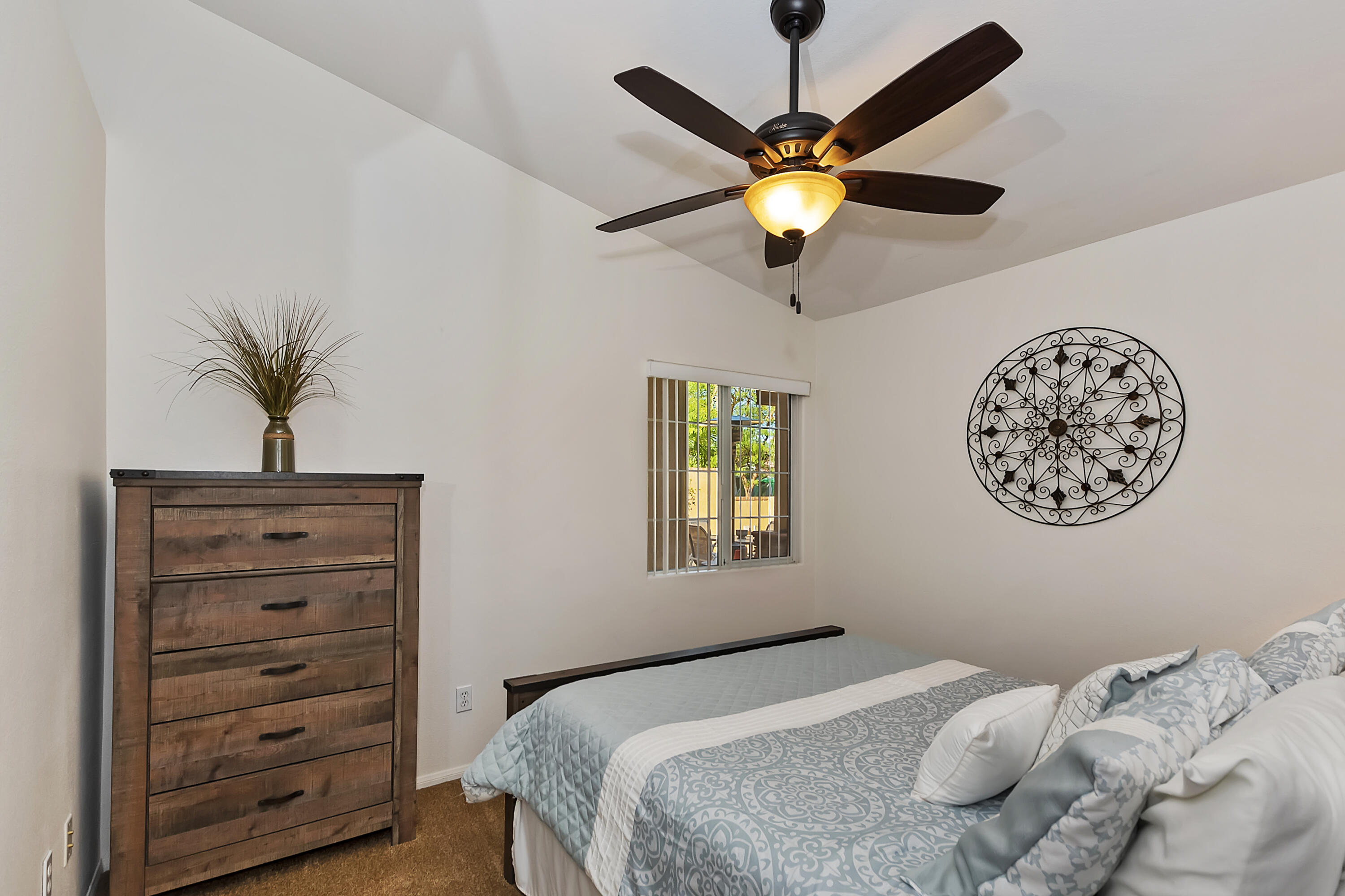 68945 Minerva Road Cathedral City, CA 92234 - Photo 23 of 42 a bedroom with a bed and a chandelier