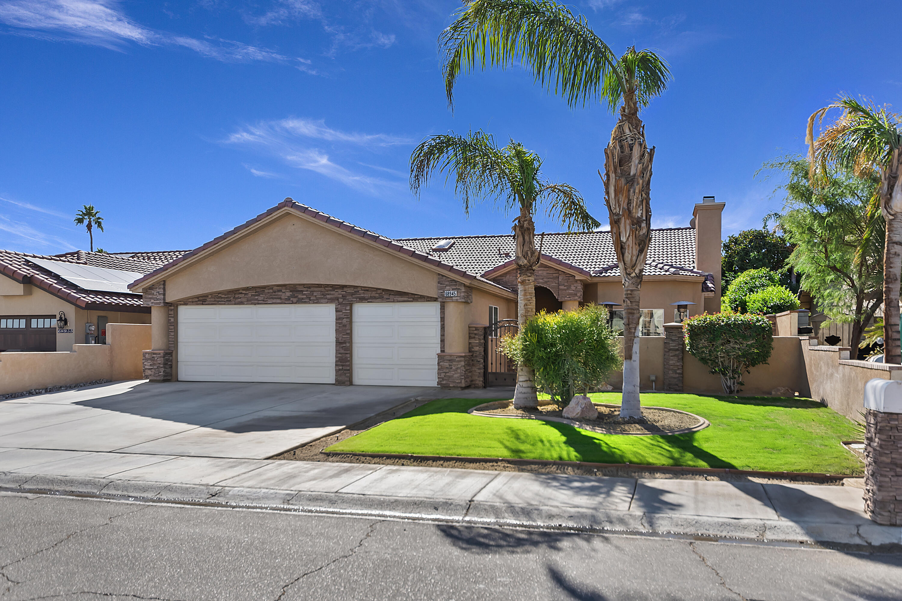 68945 Minerva Road Cathedral City, CA 92234 - Photo 4 of 42 a front view of a house with a yard and garage