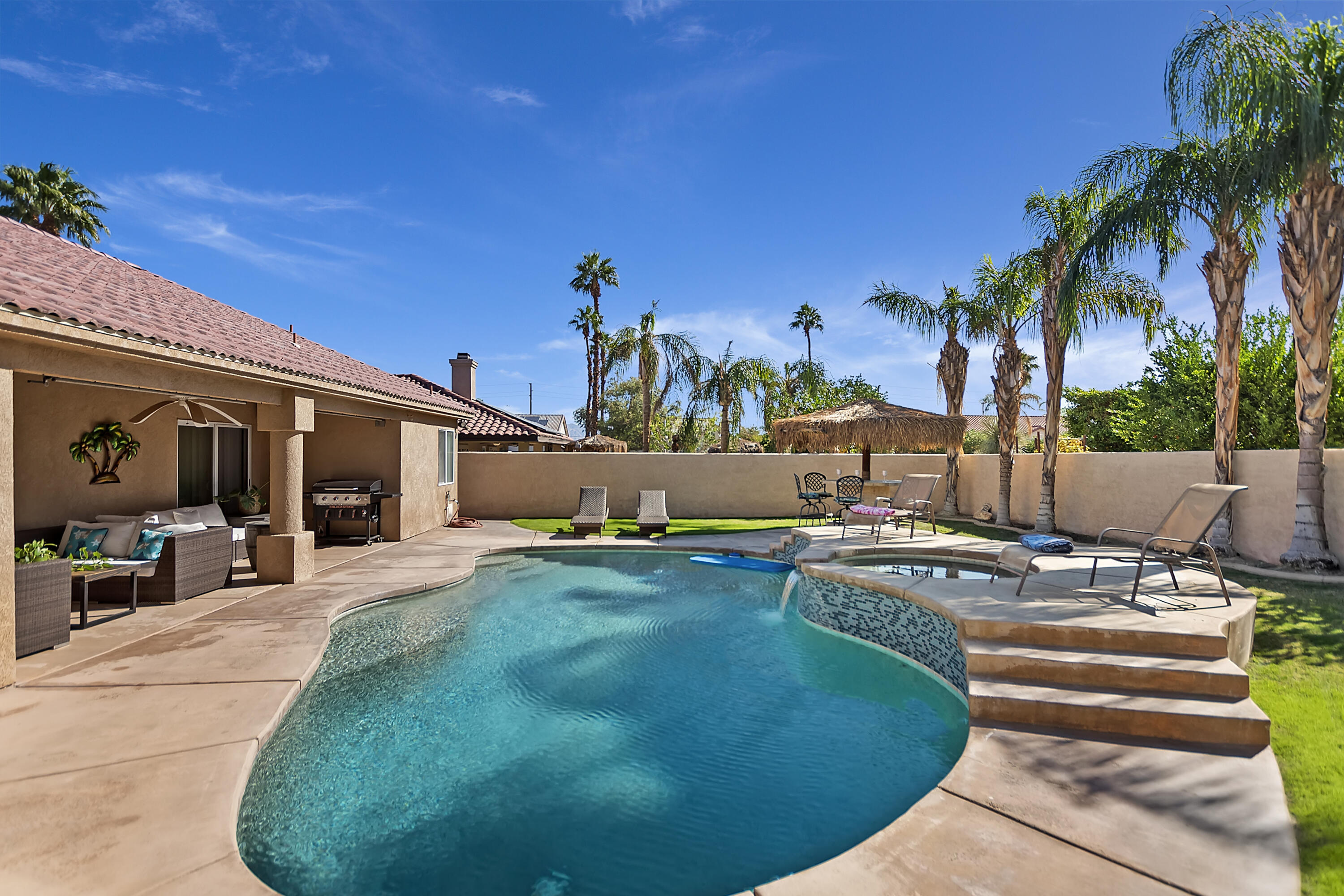 68945 Minerva Road Cathedral City, CA 92234 - Photo 38 of 42 a view of a swimming pool with lawn chairs under an umbrella