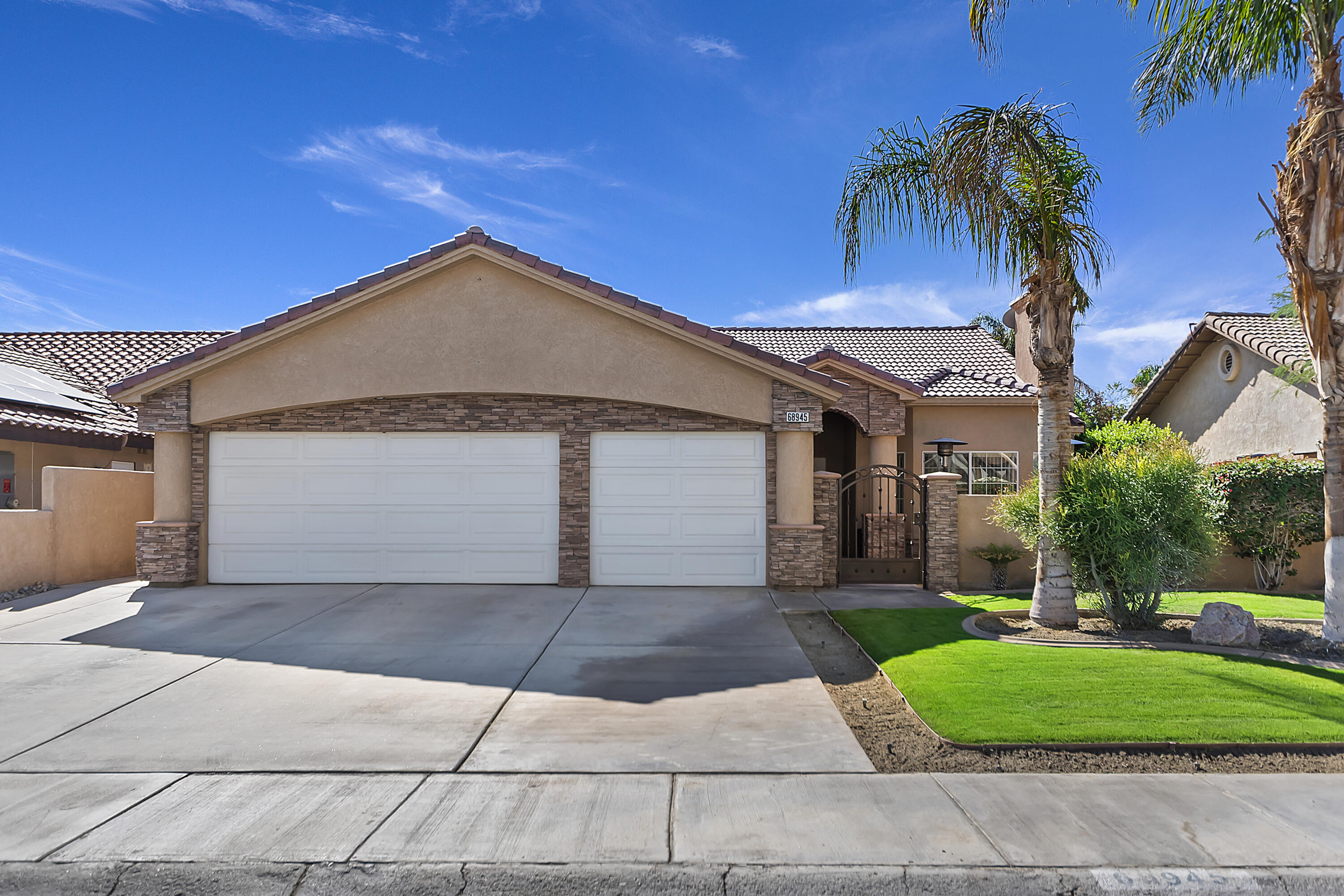 68945 Minerva Road Cathedral City, CA 92234 - Photo 41 of 42 a front view of a house with a yard and garage