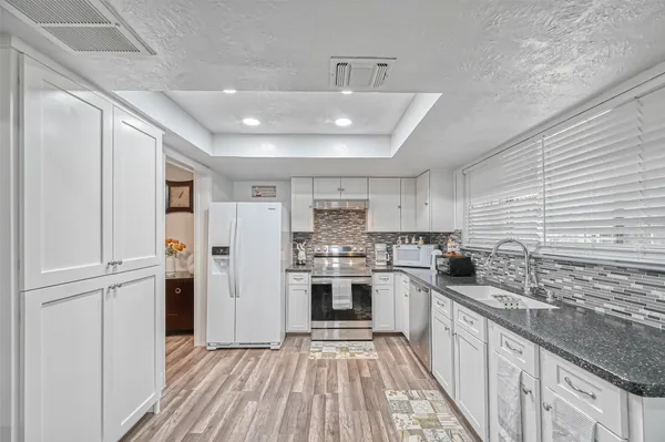 a kitchen with stainless steel appliances granite countertop a sink and stove top oven