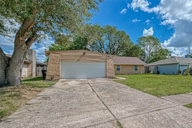 a front view of a house with a yard and trees