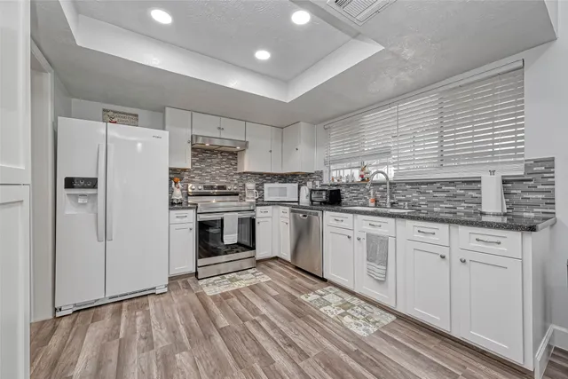 a kitchen with stainless steel appliances granite countertop a stove and a refrigerator