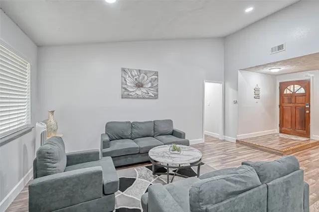 a living room with furniture and a wooden floor