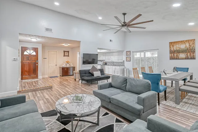 a living room with furniture and a view of kitchen