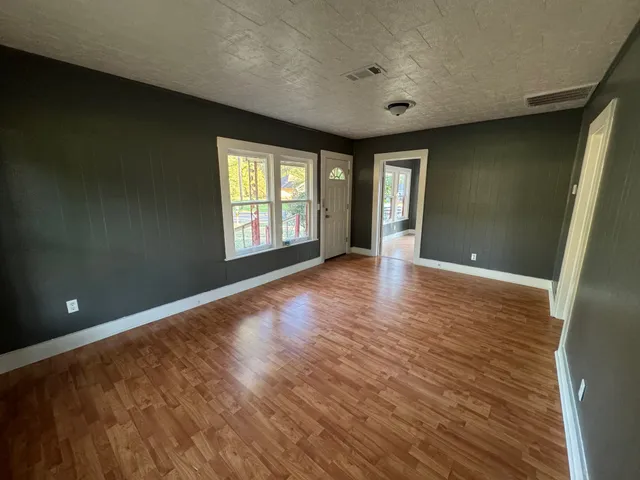 wooden floor in an empty room with a window