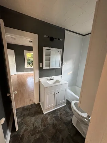 a bathroom with a sink a toilet and mirror