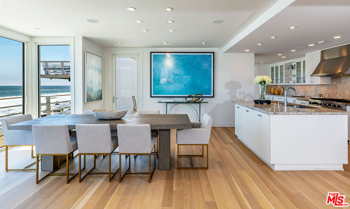 24314 Malibu Road Malibu, CA 90265 - Photo 14 of 41 a kitchen with stainless steel appliances granite countertop a table chairs sink and wooden floor