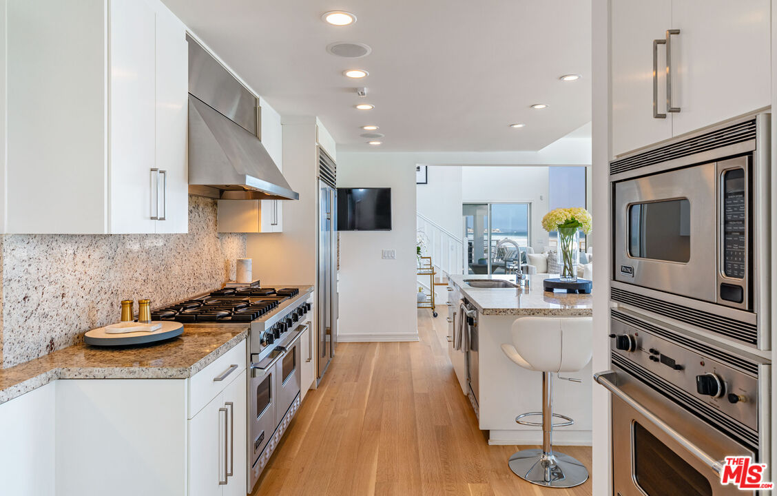 24314 Malibu Road Malibu, CA 90265 - Photo 16 of 41 a kitchen with stainless steel appliances a sink stove and cabinets