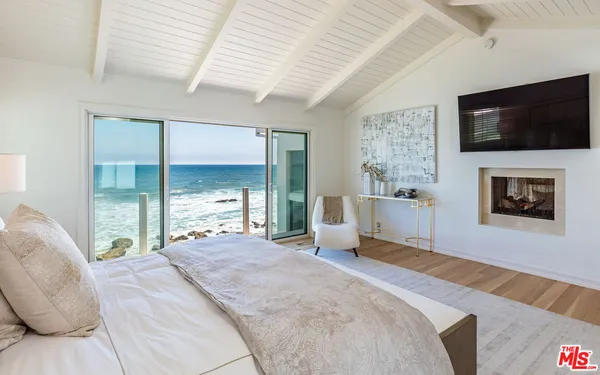 a spacious bedroom with a bed and a flat screen tv