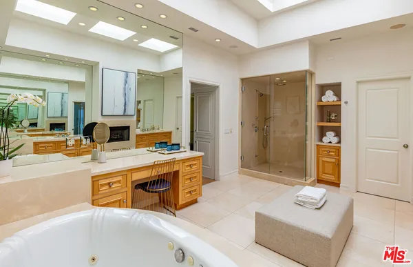 a spacious bathroom with a tub sink and mirror