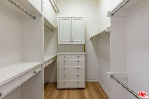 a view of walk in closet with empty racks