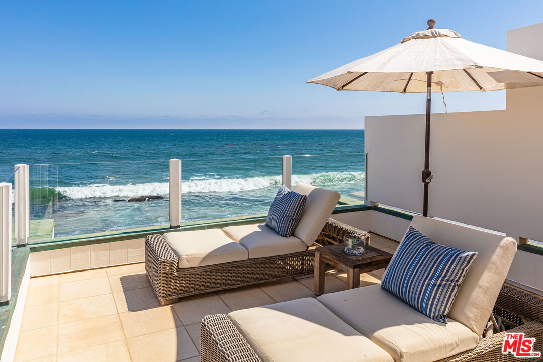 24314 Malibu Road Malibu, CA 90265 - Photo 30 of 41 a view of a patio with furniture and an umbrella