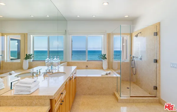 a large bathroom with a tub a sink and glass door shower