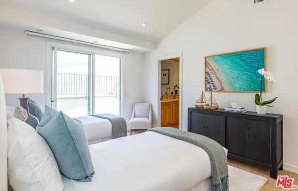 a bedroom with two beds and large window