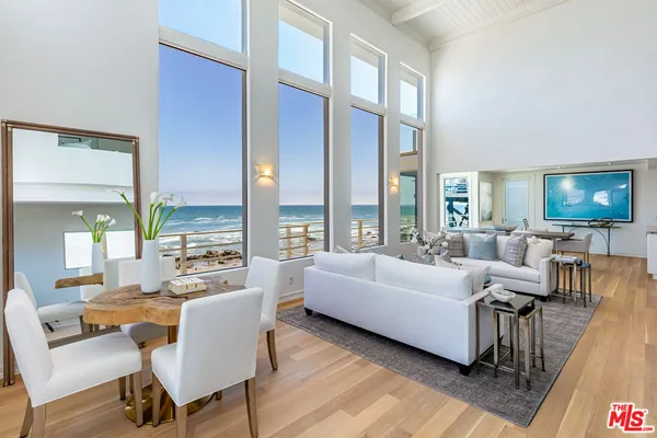 a living room with furniture wooden floor and a large window