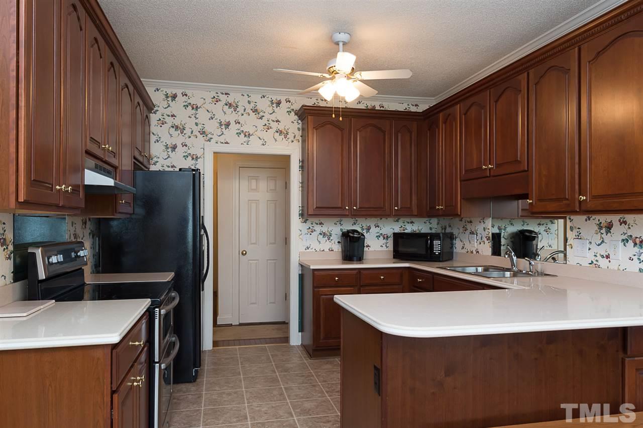 4412 Hopson Drive Raleigh, NC 27604 - Photo 8 of 25 a kitchen with a sink a stove a refrigerator and cabinets