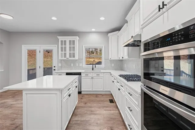 a kitchen with granite countertop a stove top oven sink and cabinets