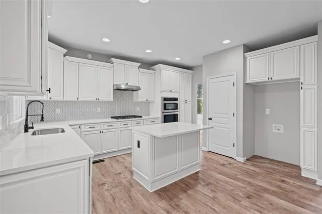 a view of an empty room with wooden floor and windows