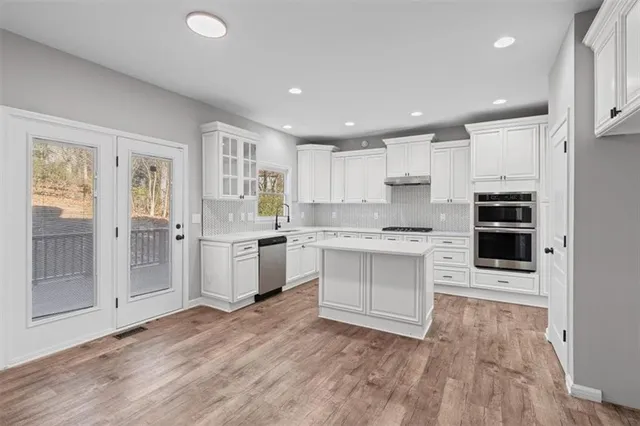 a view of a hallway with wooden floor and entryway