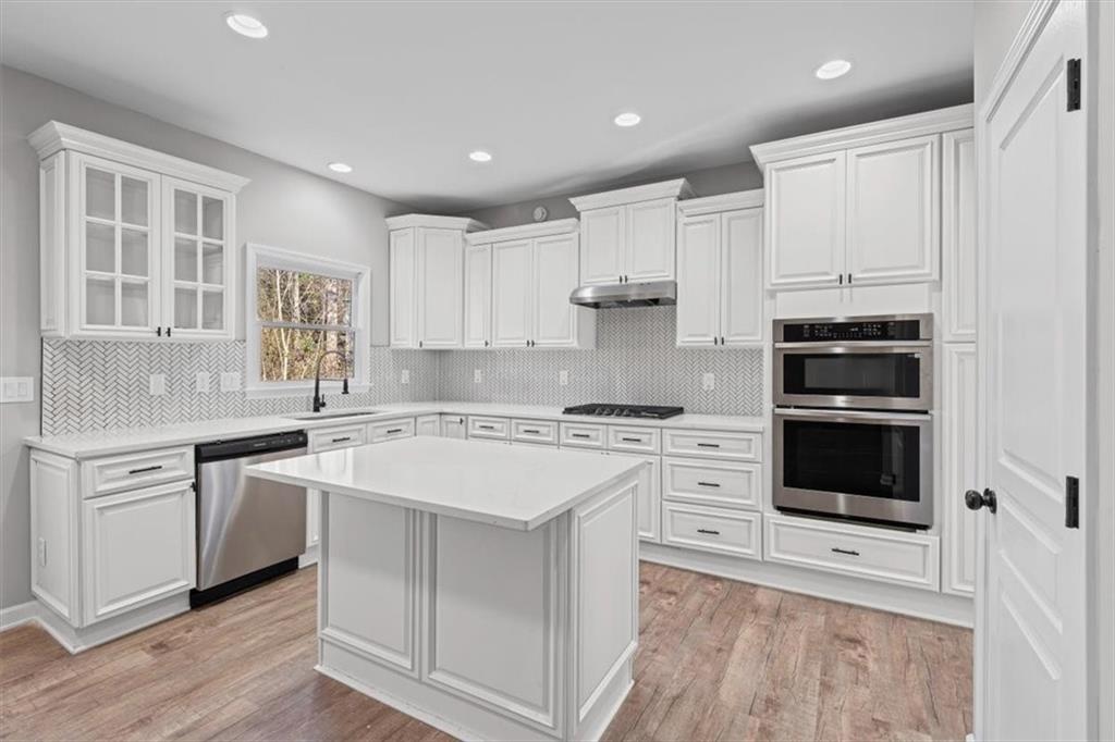 1038 Middlebrooke Drive Canton, GA 30115 - Photo 21 of 76 a kitchen with stainless steel appliances granite countertop a stove and white cabinets