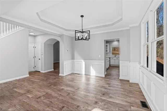 a view of empty room with wooden floor and ceiling fan