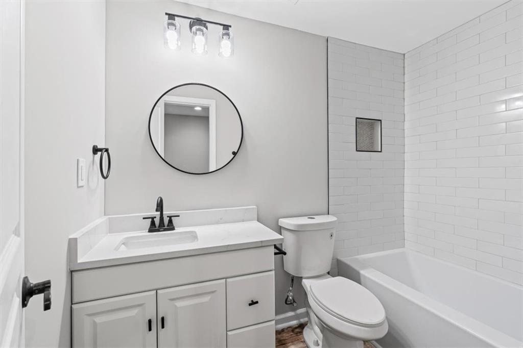 1038 Middlebrooke Drive Canton, GA 30115 - Photo 46 of 76 a bathroom with a toilet a sink a mirror and bathtub