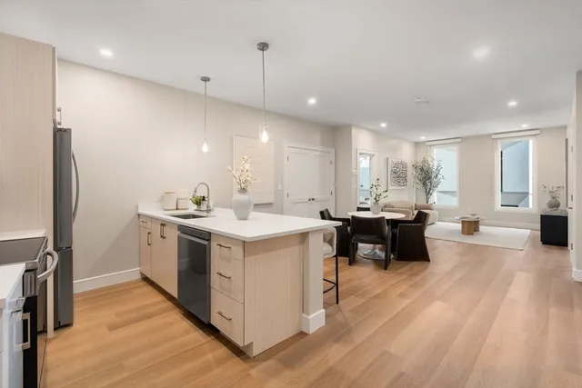 a kitchen with a sink appliances and wooden floor