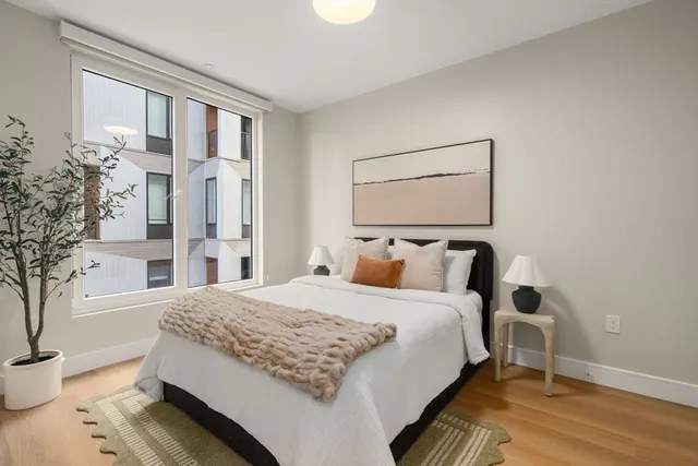 a bedroom with a bed and a potted plant