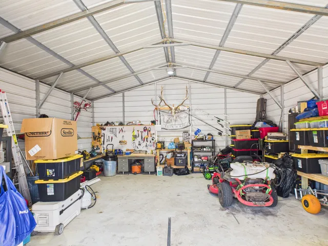 a view of a barn house next to a yard with wooden fence