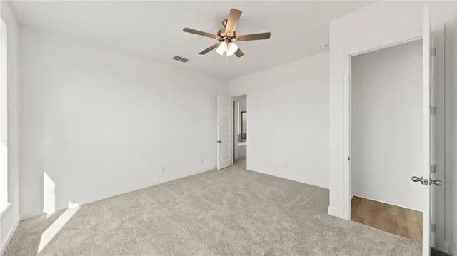an empty room with closet and ceiling fan