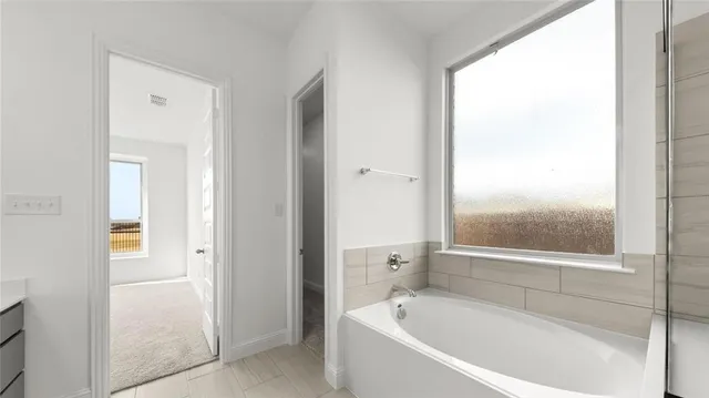 a white bath tub sitting next to a shower
