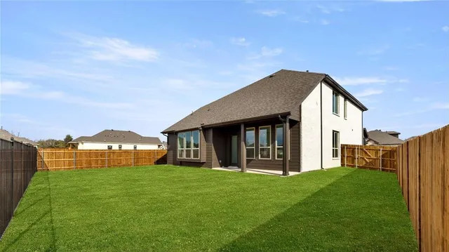 a view of a house with a big yard potted plants and large tree