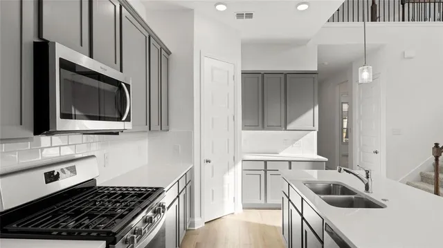 a kitchen with a sink a stove and cabinets