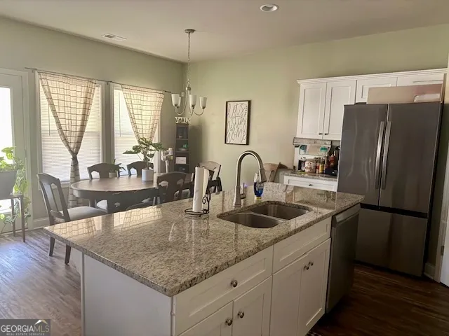 a kitchen with stainless steel appliances granite countertop a stove a refrigerator and a sink