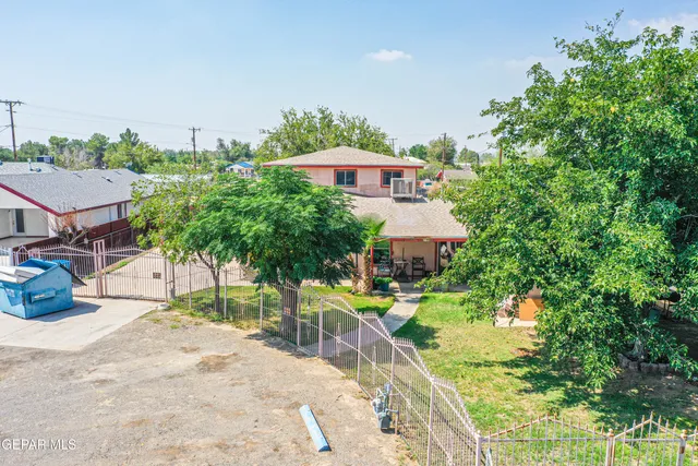a view of a house with a backyard and a tree