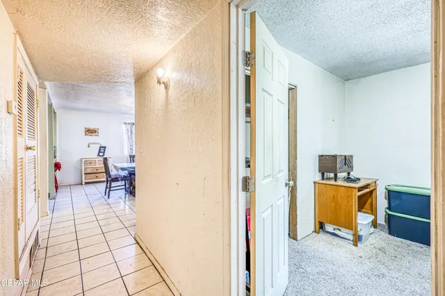 an empty room with windows and chandelier fan