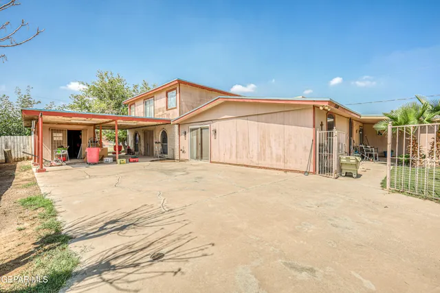 a view of a house with a yard and large tree