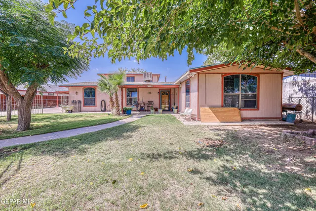 a view of a house with backyard and a tree