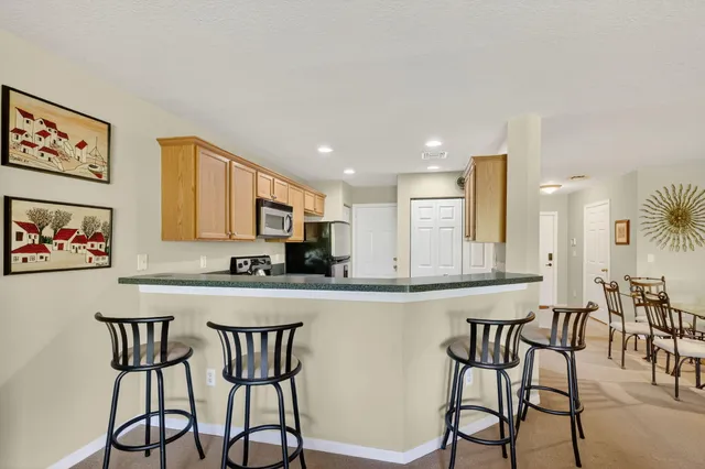 a kitchen with stainless steel appliances granite countertop a table and chairs in it