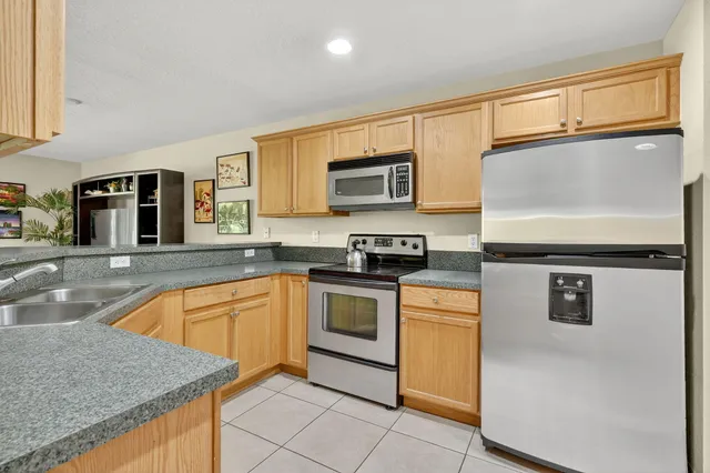 a kitchen with stainless steel appliances granite countertop a stove a sink and a microwave