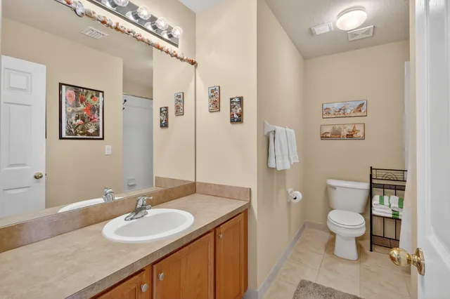 a bath room with a toilet a sink and a mirror